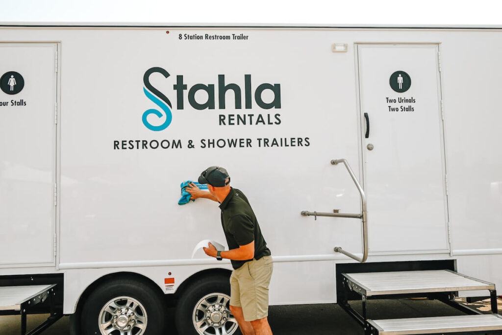 Stahla team members in front of a restroom trailer